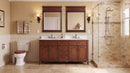 Antique brown Rocaille Victorian double vanity with white quartz top in a bathroom with two mirrors and glass shower